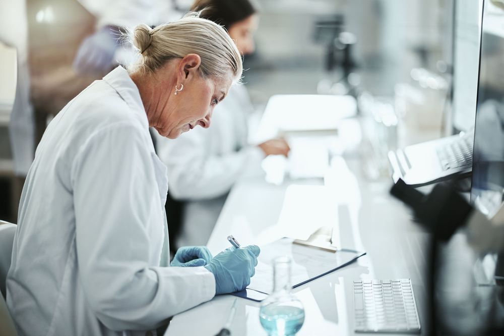 A researcher writing down results in a lab